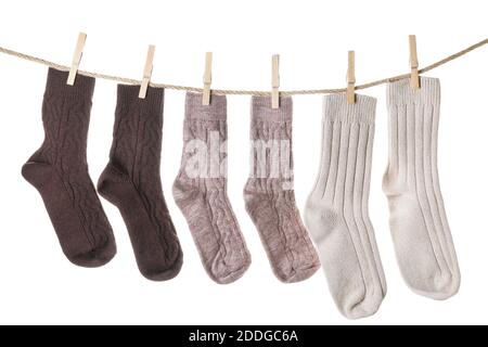 Warm socks hanging on clothes line against white background Stock Photo