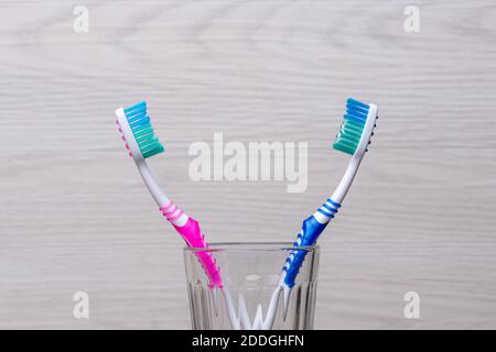 Two plastic toothbrushes in a glass in the bathroom Stock Photo