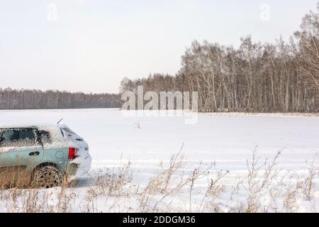 Danger of getting stuck in snow. Unexpected snowfall covered car with snow. Winter, people and car problem concept. Stock Photo