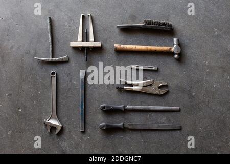 Top view of assorted shabby repair tools placed on grungy gray floor of workshop Stock Photo