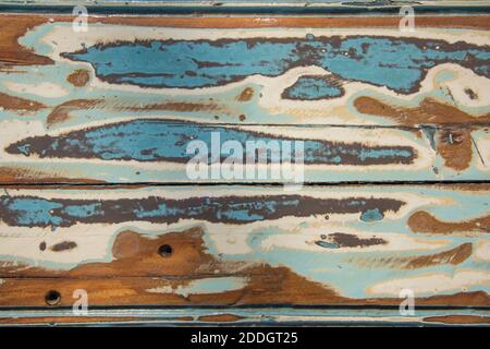 High angle view over shabby chic painted picnic table surface in full frame detail with baby blue, cream and brown coloring. Stock Photo
