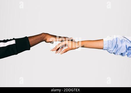 Close-up of a man's black hand on a Woman's white hand over white background Stock Photo