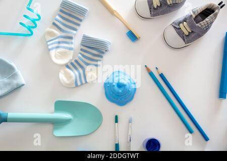 Baby boy shower flat lay concept. Newborn pastel blue color clothing and accessories on white background, top view. Stock Photo