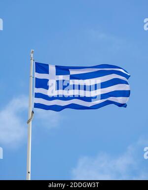 Greek flag waving on pole against clear blue sky background, copy space. Greece national sign symbol Stock Photo