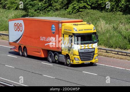 Mark Thompson Ltd Haulage delivery trucks, lorry, heavy-duty vehicles, TNT transportation, truck, cargo carrier, DAF vehicle, European commercial transport industry HGV, M6 at Manchester, UK Stock Photo