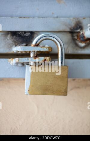 Heavy metal padlock closeup on an entrance gate, vertical closeup view. Safety, security concept Stock Photo