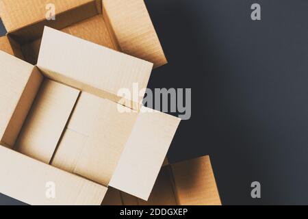 Empty open brown cardboard boxes on dark gray color background. Top view Stock Photo
