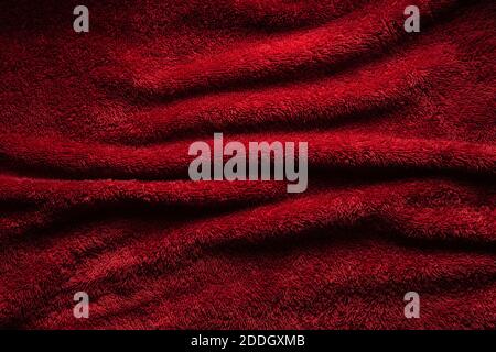 A soft red terry towel. Burgundy texture background. Underlay and free space for text. Stock Photo