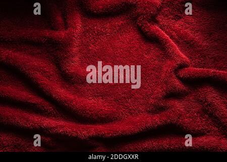 A soft red terry towel. Burgundy texture background. Underlay and free space for text. Stock Photo