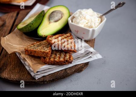 Sandwiches with soft cheese, avocado and cucumber. Breakfast is on the table. Healthy food. Toast and spread on it. Avocado sandwich stilllife Stock Photo