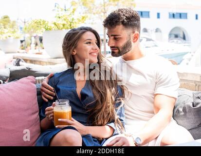 Young couple sitting at a restaurant and looking at each other. Stock Photo
