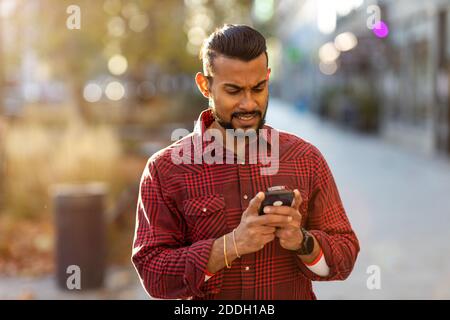 Handsome young man using mobile phone at the street Stock Photo