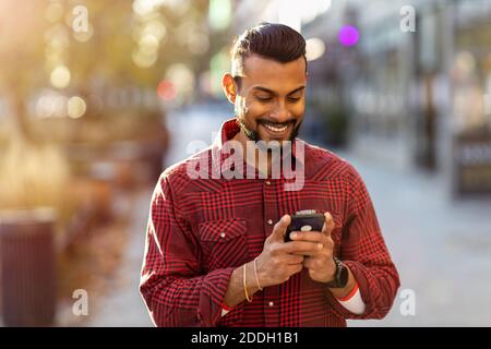Handsome young man using mobile phone at the street Stock Photo