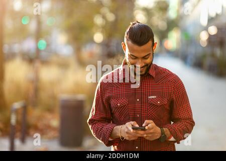 Handsome young man using mobile phone at the street Stock Photo