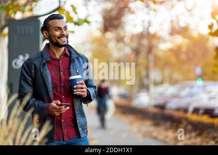 Handsome young young man drinking coffee in the street Stock Photo