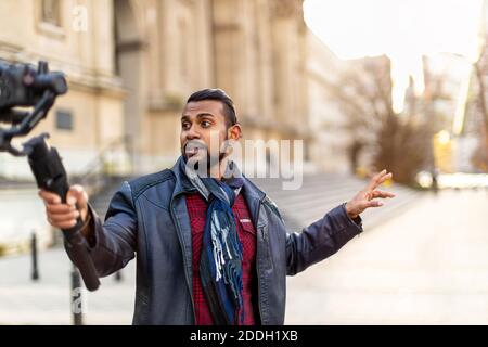 Man filming a vlog with camera in the city Stock Photo
