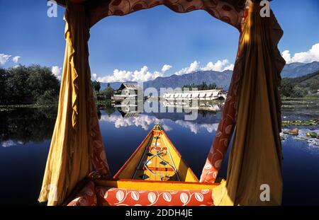 19.08.2010, Srinagar, Jammu and Kashmir, India, Asia - A traditional wooden Shikara boat with its typical drapes and baldachin crosses the Dal Lake. Stock Photo