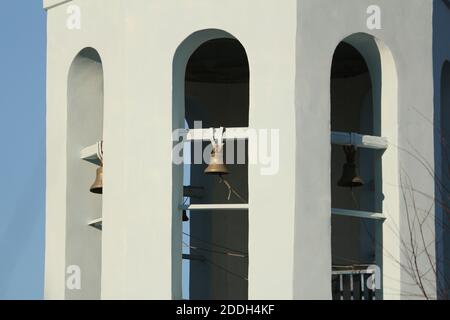 Belfry with copper bells on the bell tower of the Orthodox Church. Metal bells hang in the vaults of the bell tower of an Orthodox church in Russia . Stock Photo