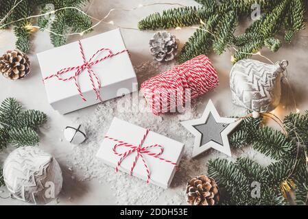 Christmas composition of gift boxes, fir branches and garland on gray background. Stock Photo