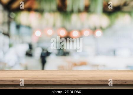 Empty wood table and blurred light table in coffee shop and cafe with bokeh background. product display template. Stock Photo