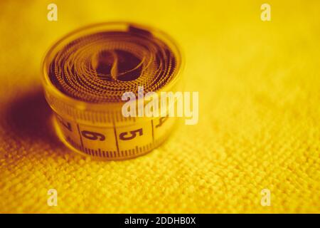 Yellow measuring tape in closed box on the towel ttable Stock Photo