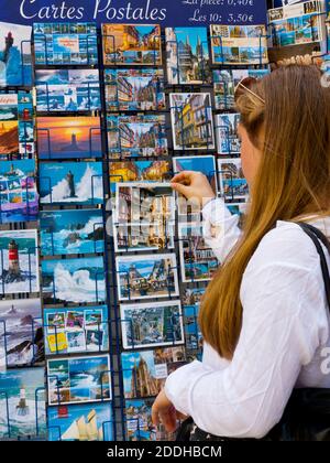 Tourist browsing postcards for sale in a shop in Quimper city centre Finisterre Brittany France. Stock Photo