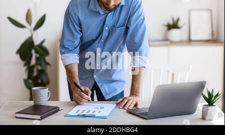 Businessman taking notes to financial report, working with documents at office, cropped Stock Photo