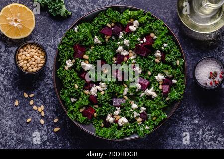 Healthy raw kale and beetroot salad with feta cheese and pine nut. Top view. Stock Photo