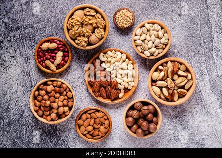 Various Nuts in wooden bowls, top view. Stock Photo