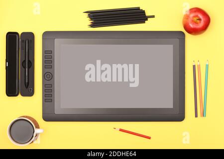 Graphic monitor stylus and glove on yellow color table. Black tablet computer with blank screen. High resolution photo. Full depth of field. Working e Stock Photo