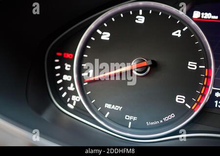 Rev counter of car selective focus closeup with copyspace.Tachometer or revolution counter, RPM gauge with red glowing needle on car dashboard with Stock Photo