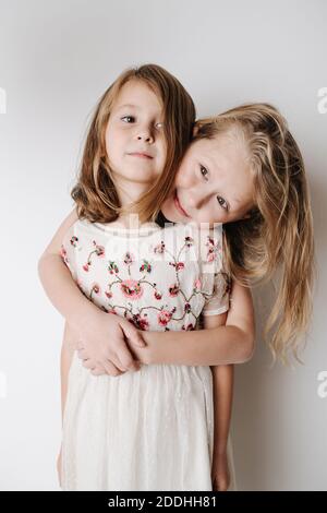 Brother hugging sister from behind. Siblings of elementary school age together Stock Photo