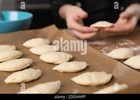 Women preparing homemade food pie, pizza in a cozzy kitchen. Hobbies and family life concept. Stock Photo