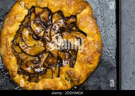 Rustic apple tart with cinnamon apricot jelly glaze and sugared shortcrust on baking tin with copy space - top view close up image Stock Photo