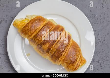 Croissant on white plate with copy space - top view close up image Stock Photo