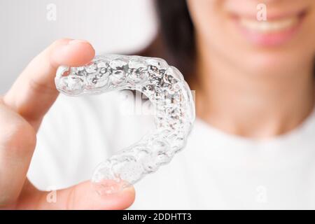 Close up orthodontic transparent aligner in womans hand. Removable braces. Stock Photo