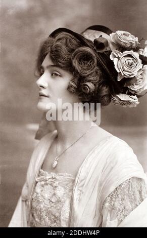 The notable Edwardian English actress and singer Lily Elsie (1886 – 1962) wearing a flowery hat, taken from a photographic postcard from the era. Stock Photo