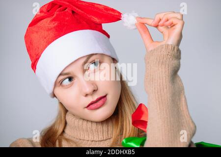 Cute portrait of a girl in a santa hat on a white background. Holiday concept. Stock Photo