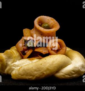Stewed calamari with peas, potatoes, onion, parsley, tomato, pepper, salt, oil and lemon zest on crispy bread. Stock Photo