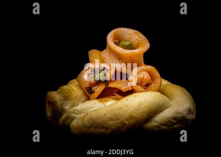 Stewed calamari with peas, potatoes, onion, parsley, tomato, pepper, salt, oil and lemon zest on crispy bread. Stock Photo