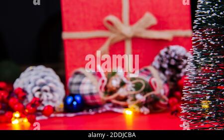 Christmas ornament, Christmas tree light, cones and snowy Christmas tree standing in front of the big New Year gift box Stock Photo