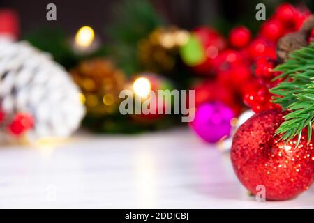 bright red christmas ball standing in front of pine tree light and various christmas decorations Stock Photo