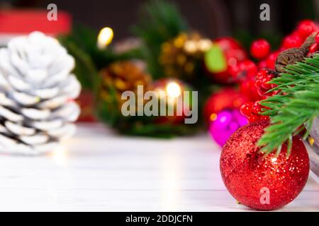 bright red christmas ball standing in front of pine tree light and various christmas decorations Stock Photo