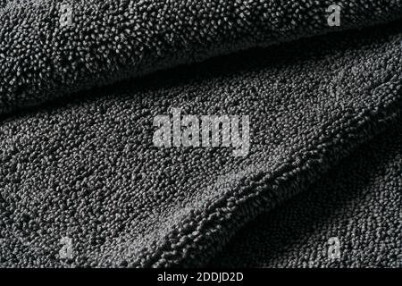 Gray cleaning rag microfiber cloth or towel for cleaning and household. Abstract dark fabric textile background. Stock Photo