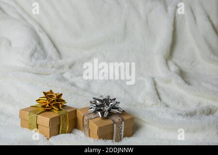 gift boxes packing with a bow and ribbon in gold and silver color on a plush knitted blanket with a copy space Stock Photo