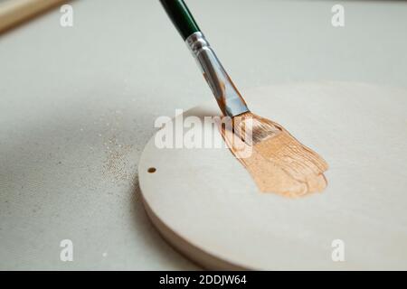 brush stroke of gold paint with glitter on light wood.  Stock Photo