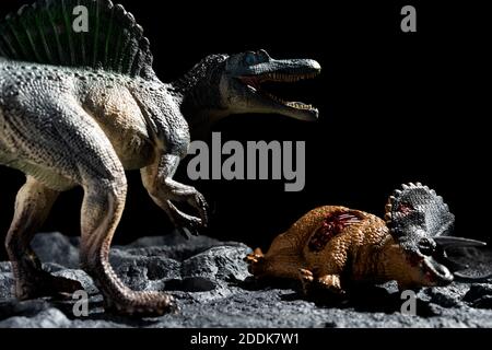 spinosaurus with a triceratops body on a ground with craters Stock Photo