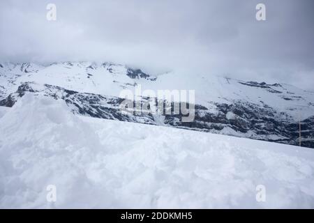 Fog falling over the rocky mountains of the Andes covered by white snow that heralds Christmas atmosphere Stock Photo