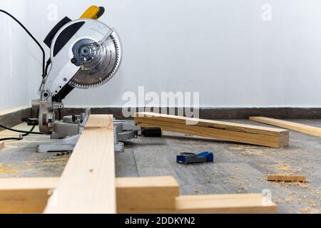 Yellow miter saw cutting wood Stock Photo