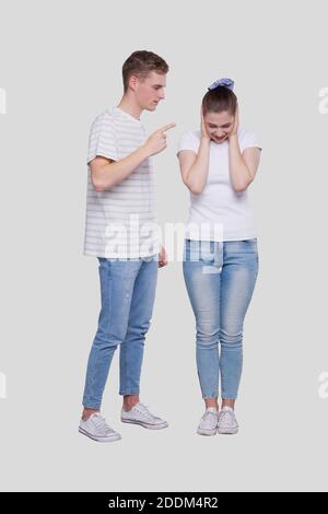 Couple Having a Fight. Man Screaming at Girl. Man is not Satisfied. Couple Standing Isolated. Girl Closing Eyers Stock Photo